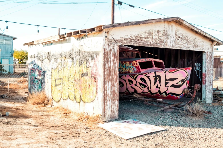 a garage with some graffiti on it and two cars parked