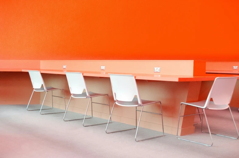 a row of chairs sitting by a long table