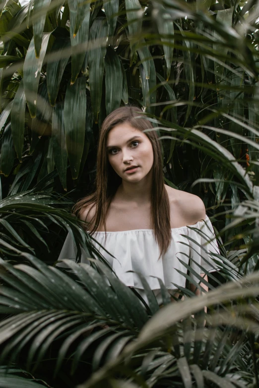 a girl stands in the jungle with palm trees