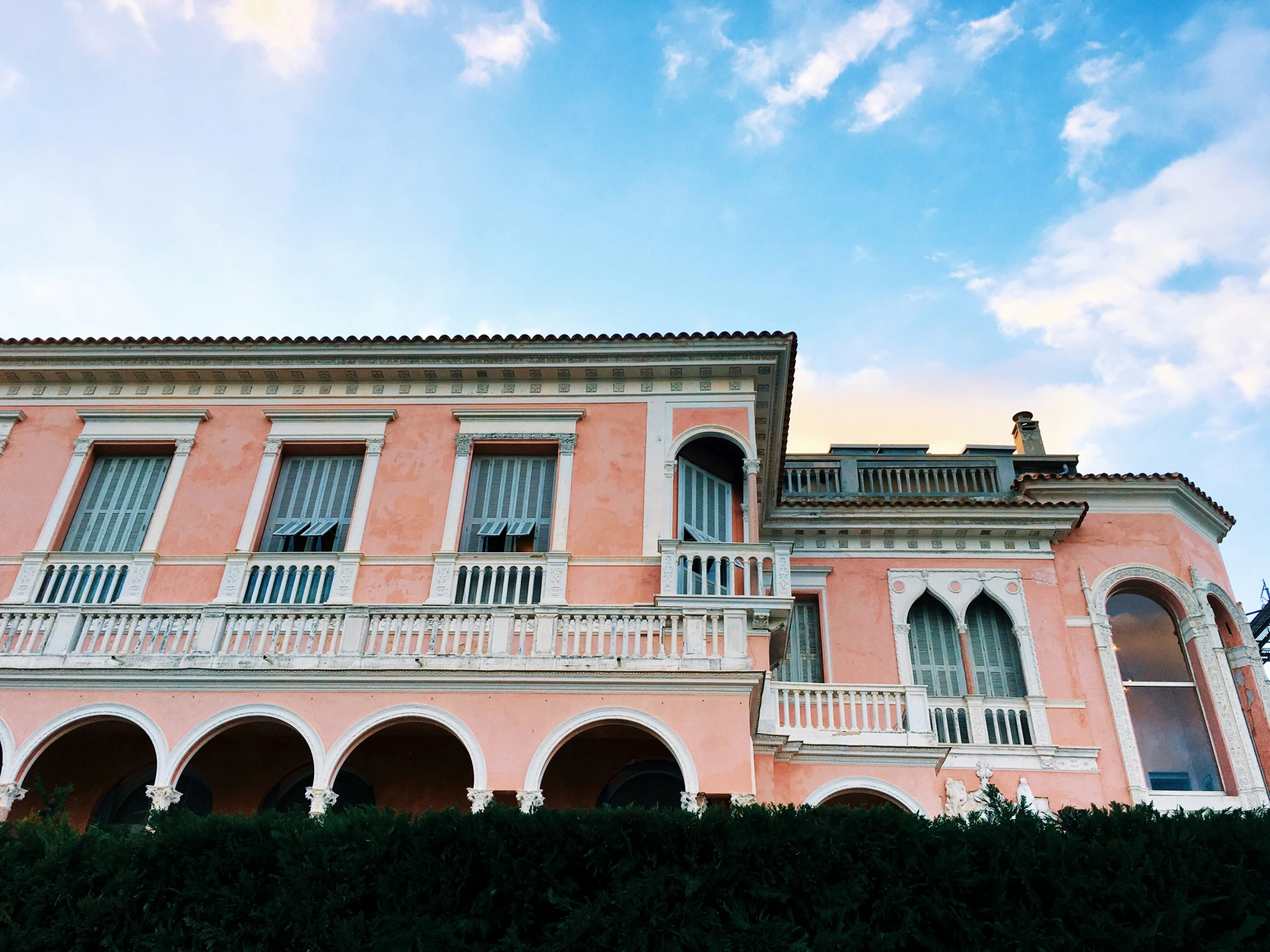 pink buildings that are lined up and facing a blue sky