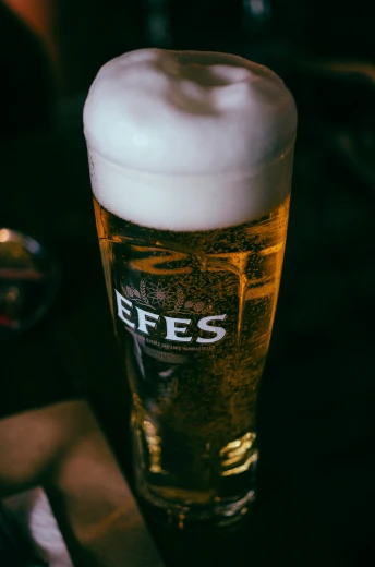 a tall glass of beer on top of a table