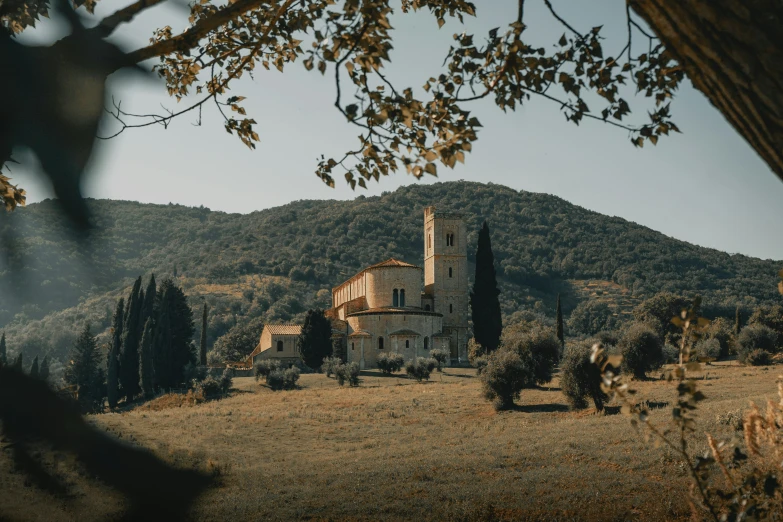 a white building with a tower near a hill