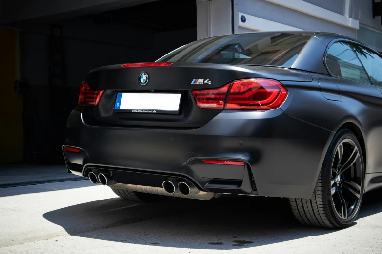 the front end of a grey bmw car in a driveway