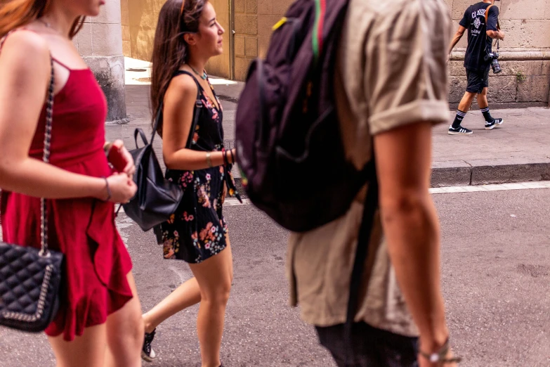 a group of people standing on the sidewalk