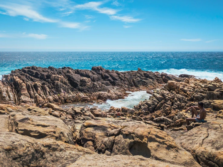 a  stands on the edge of some rocky outcropping