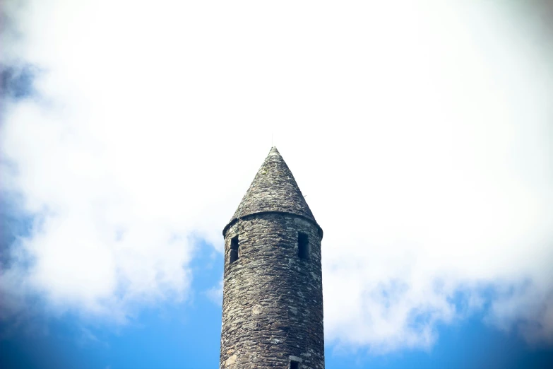 a large tower on top of a building surrounded by clouds