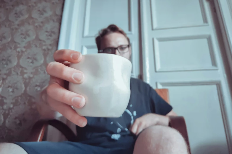 a person holding up a cup with soing in it