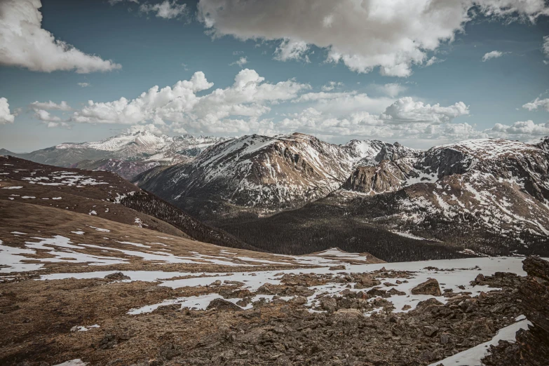 a snow covered mountain landscape with a small patch of clouds