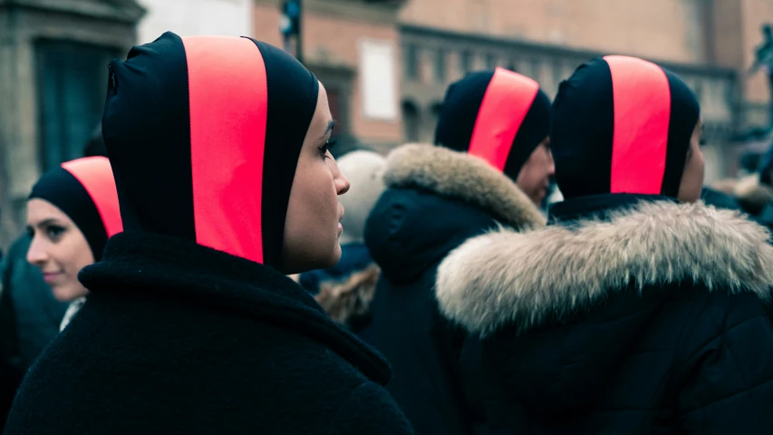 several people are lined up wearing red and black hats