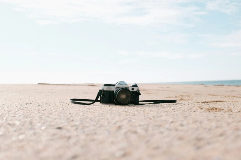 a camera is sitting on the sand at the beach