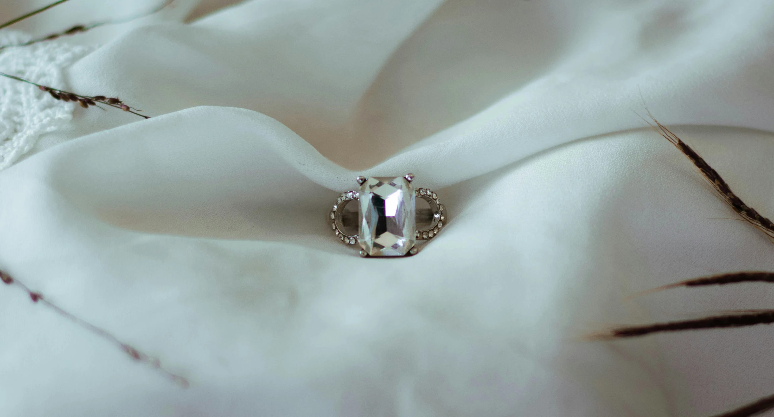 a close up view of an elegant ring and a white cloth