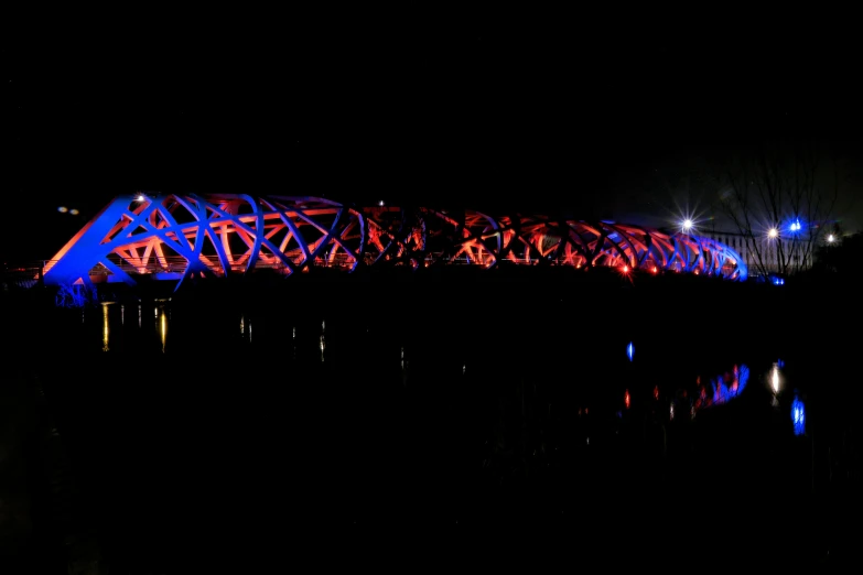 a lit bridge across a body of water