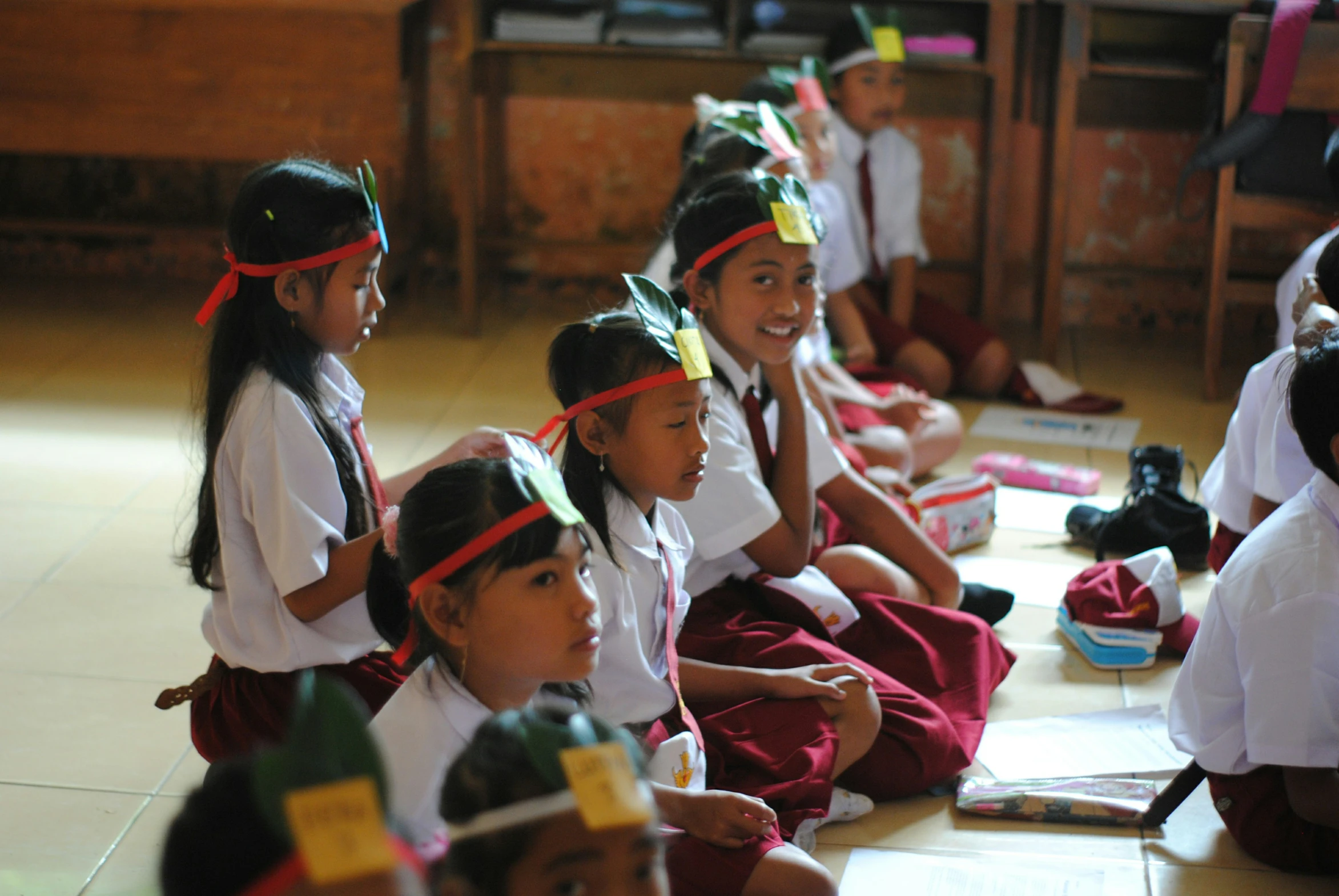 several small children in hats sit and smile for a po