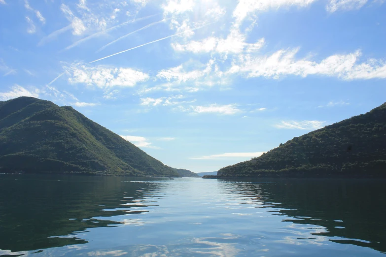 the sky is very bright as the water reflects a lake