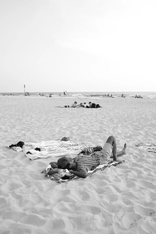 people are lying on a beach with towels and towels