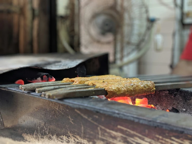 a bbq being cooked with food on it and tongs