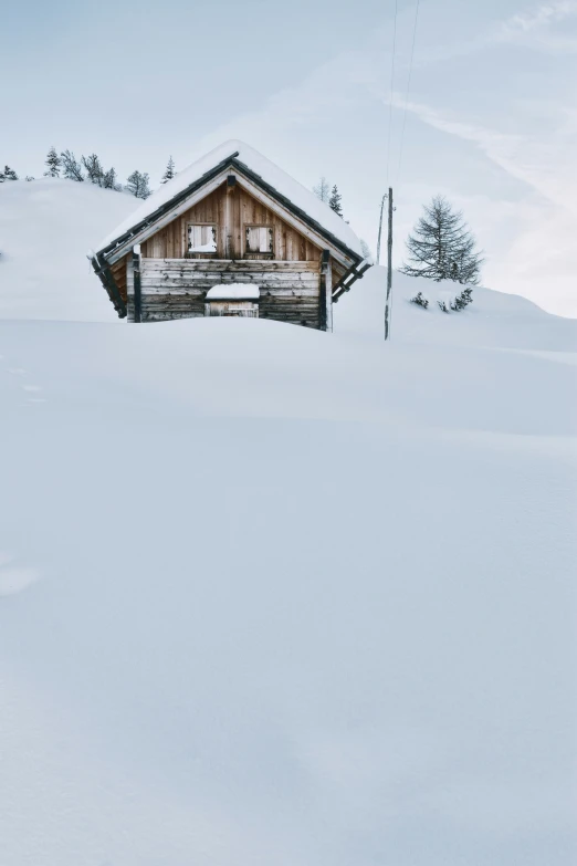 a small house sitting on top of snow covered mountains