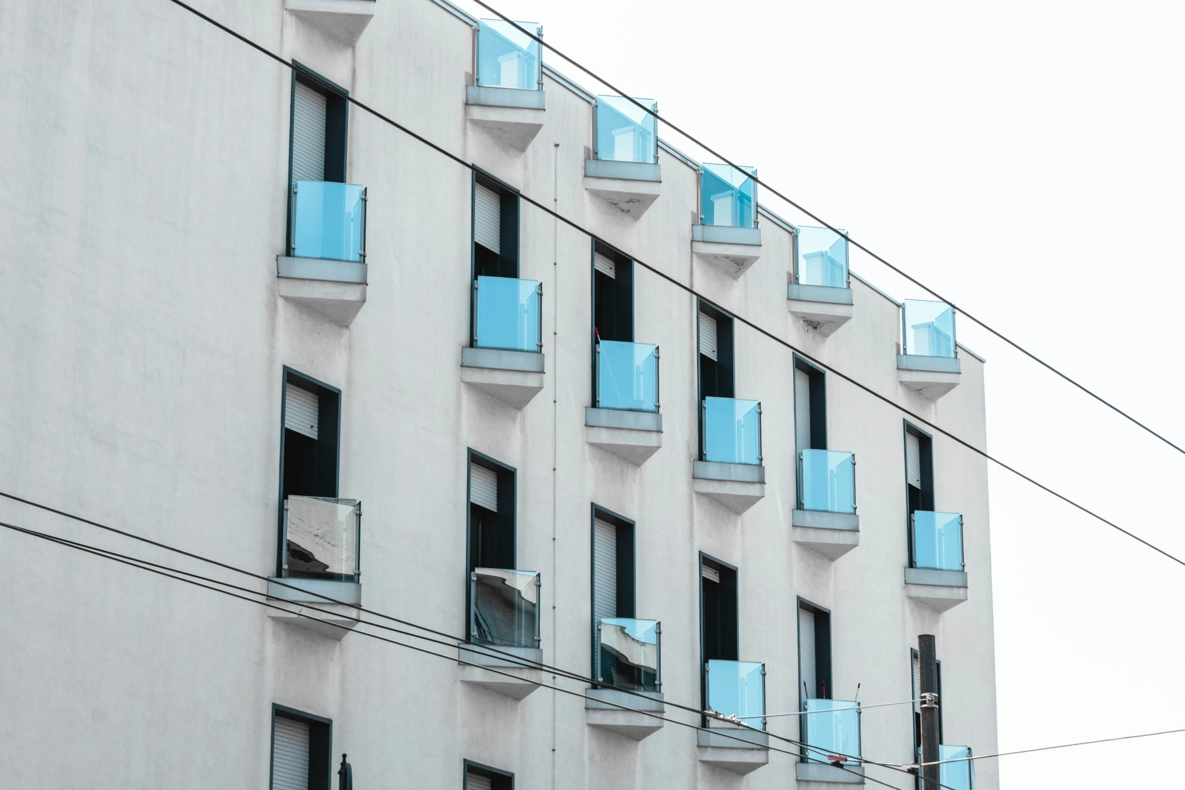 several windows on a building with blue glass and wires