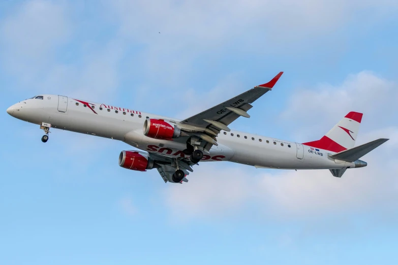 a qantas airplane flying thru the air with clouds in the background