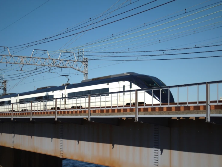 a white and black train traveling over a bridge