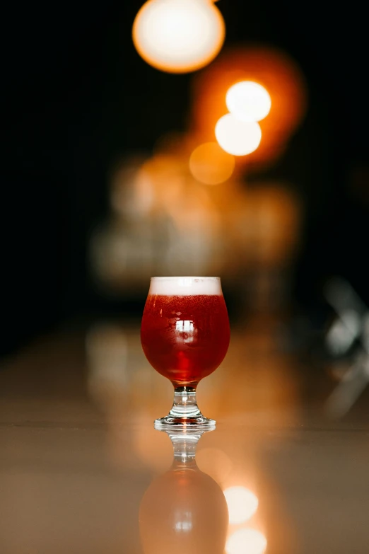 a s of a red beer sitting on top of a table