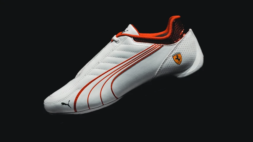 a white and orange shoe with a red stripe on the side