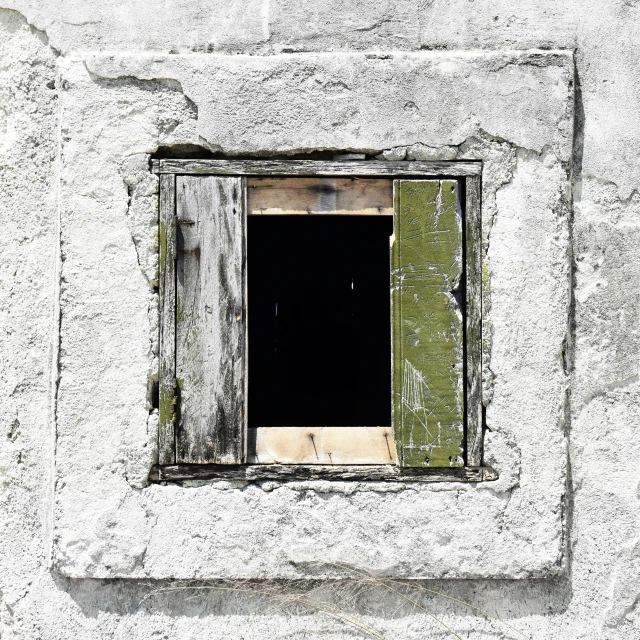 there is a broken window in the stone wall