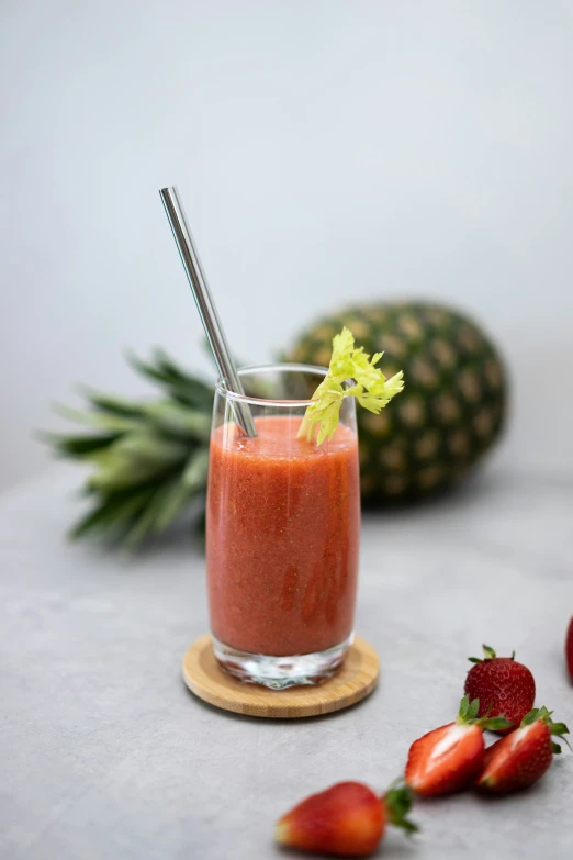 a glass with some strawberries in it on a table