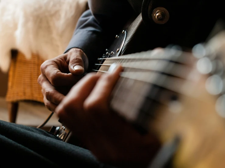 man playing a guitar with one hand