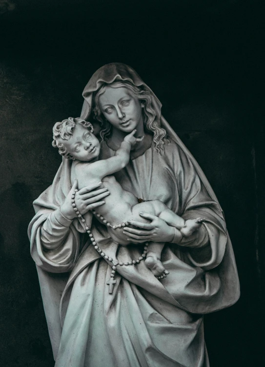 statue of virgin mary holding child in white paint