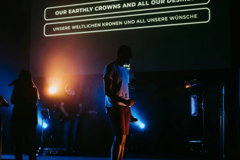 a group of people stand on stage while a large screen is being projected