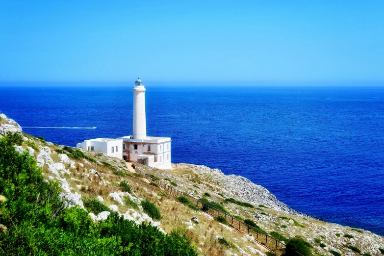 a light house sitting on top of a hill next to the ocean