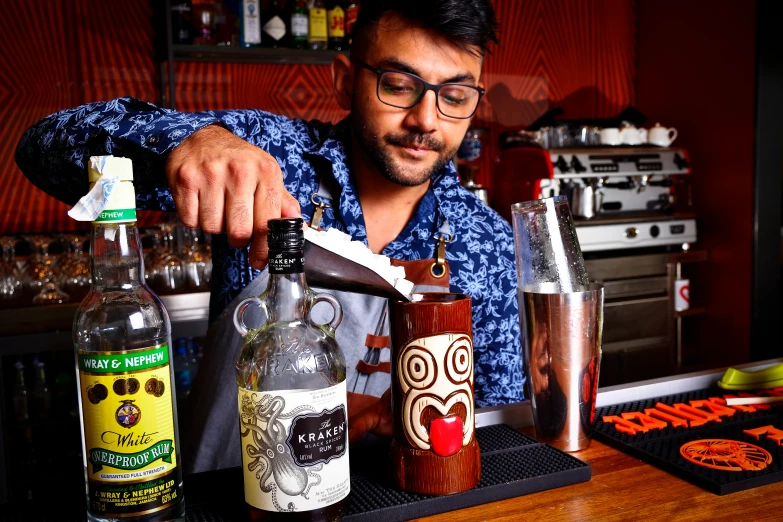 man at bar using  shear to cut glass bottle with sharp knife