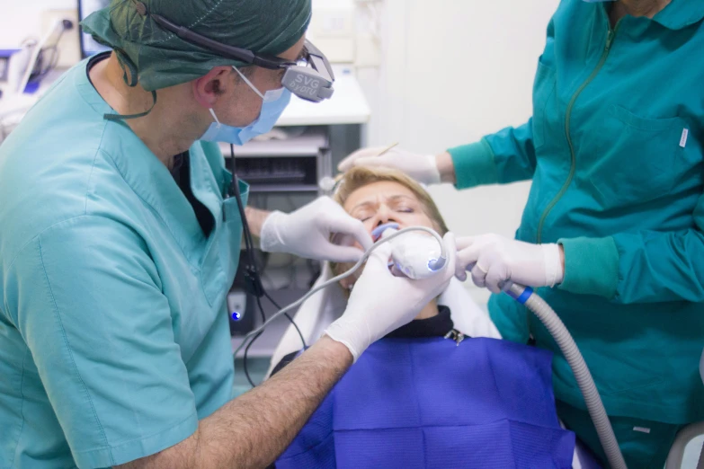 two dentists doing operation on a woman with broken thumb