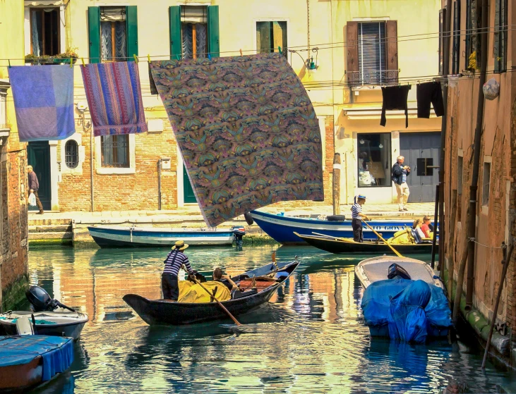 several boats are seen floating in the water near a building