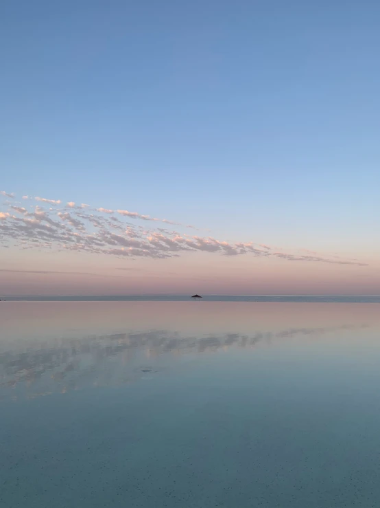 the water with the sky above it has some clouds in the sky