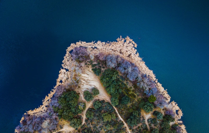an aerial view of an island and blue waters