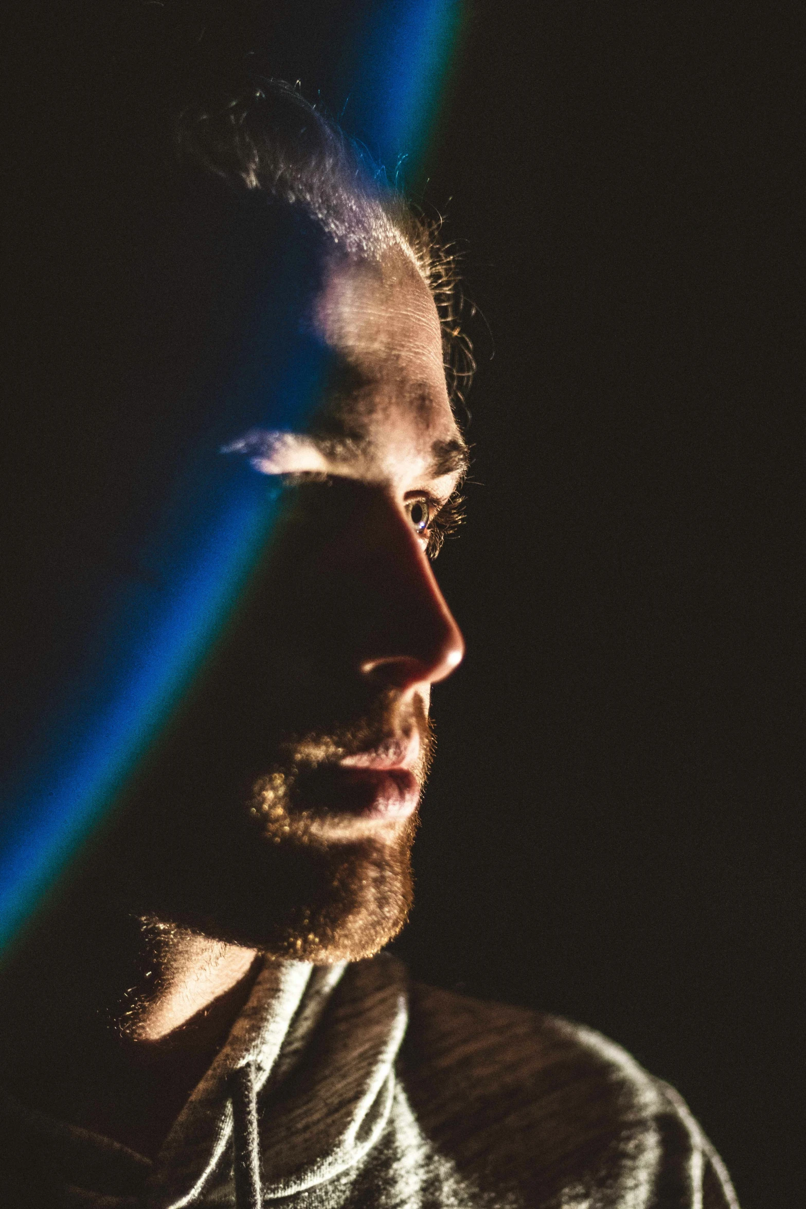 a man in a black shirt looks away from the camera