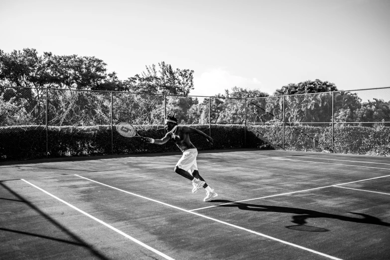 a man on the tennis court swinging at a ball