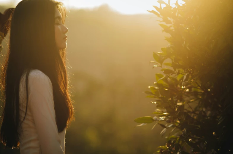 a woman with long brown hair is in the sunlight