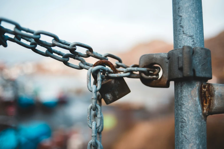 a large metal gate with a rusty lock attached to it