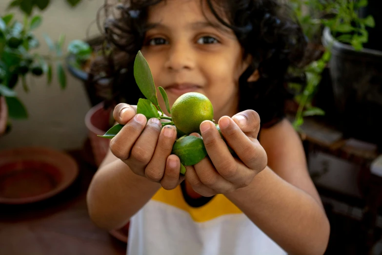 a small child holds on to a small piece of fruit