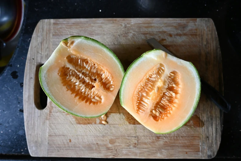 two halves of a melon on a chopping board
