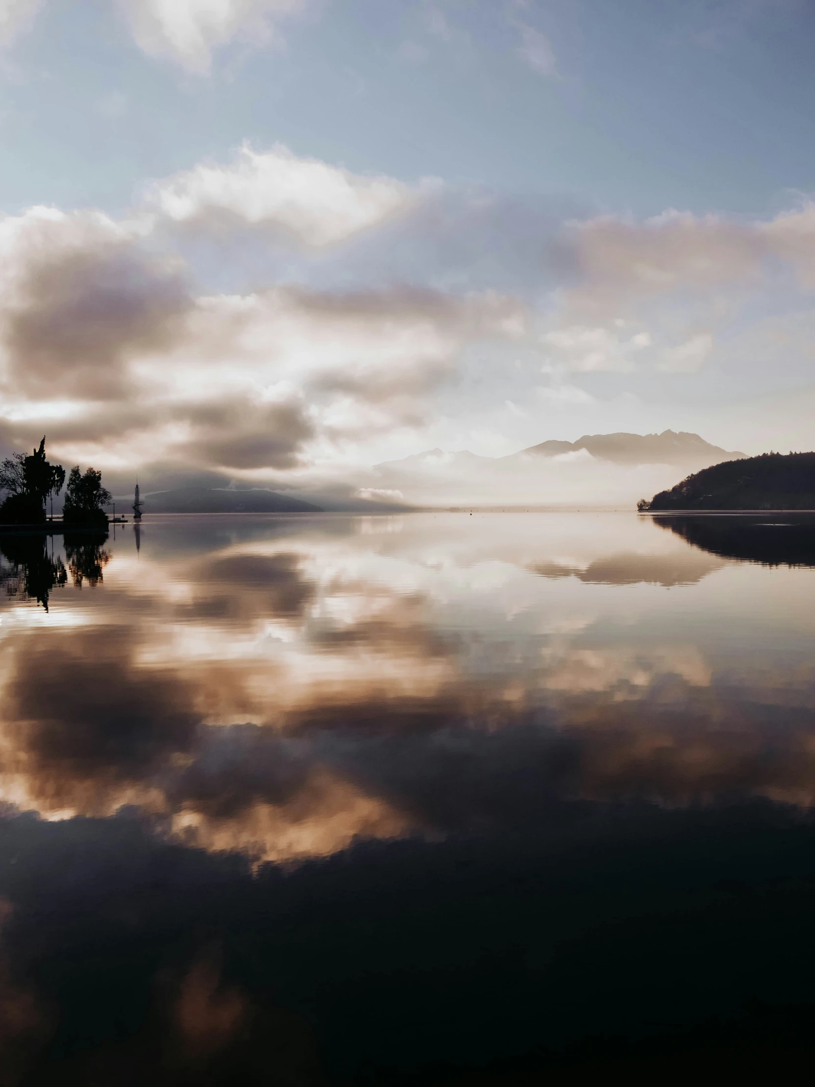 the reflection of trees in water on the calm surface