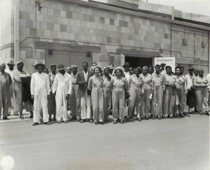 an old pograph shows a group of people standing on the street