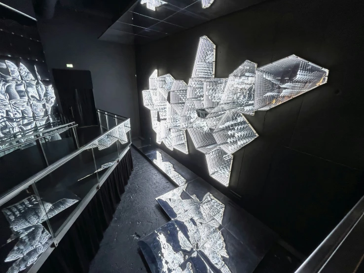 a room with a glass case and sculptures on the wall