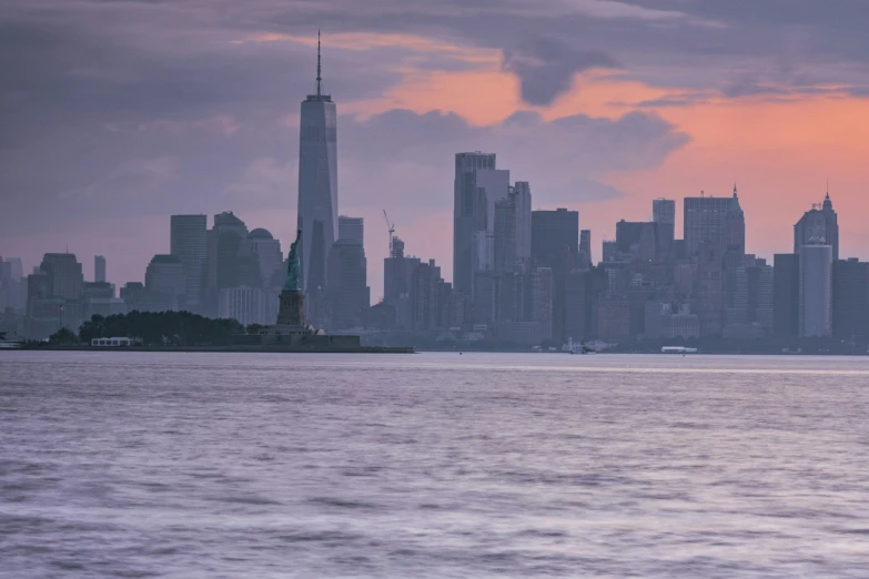 the skyline of a large city as it stands before a very cloudy sunset