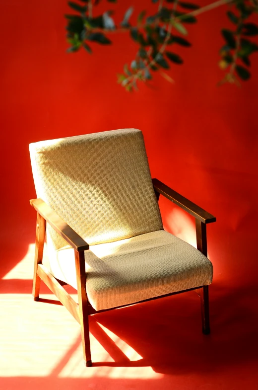 an old chair that is against a red wall