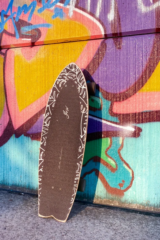 a skate board is leaning against the wall with graffiti