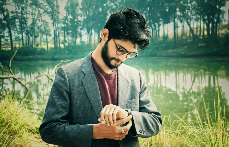 a man in suit and tie looking at a cellphone